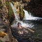 Wild Swimming Walks in Northumberland - Woman Swimming with Small Waterfall